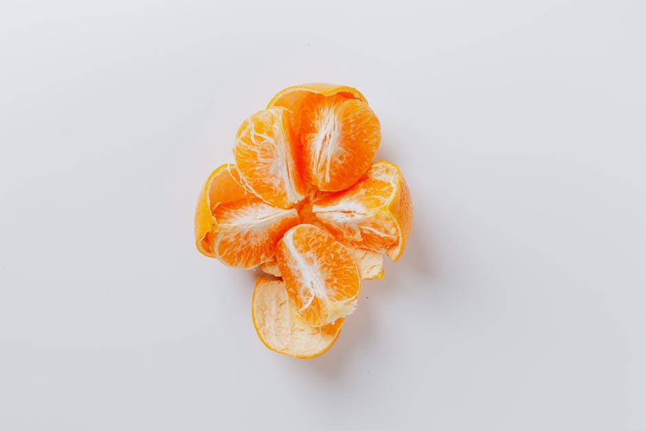 A close-up image of a Cara Cara Navel Orange, showcasing its vibrant, pinkish-red interior and juicy segments.