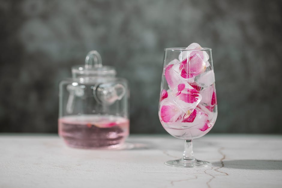 A glass of traditional Thadal with a garnish of rose petals serving as a refreshing summer drink in Pakistan